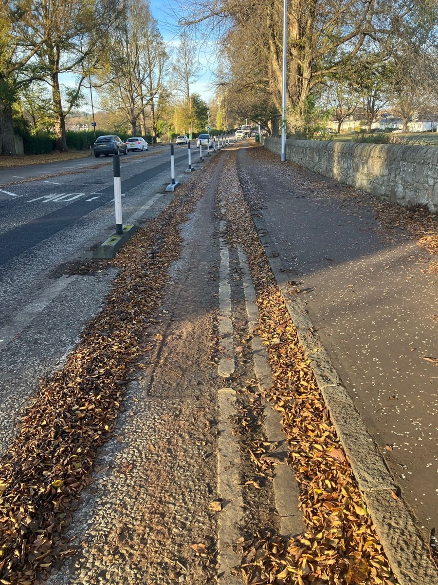 Ice and leaves covering Queensferry Road bike lane, especially in the middle distance in the shade